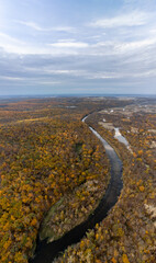 Aerial autumn river curve vertical panorama with golden forest and cloudy sky