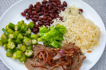 Traditional rustic Brazilian lunch, beans, rice, steak, okra and lettuce. Executive made dish