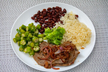 Traditional rustic Brazilian lunch, beans, rice, steak, okra and lettuce. Executive made dish