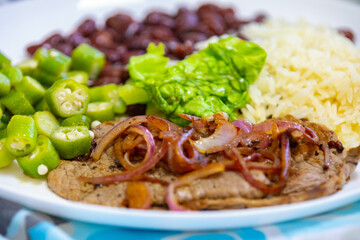 Traditional rustic Brazilian lunch, beans, rice, steak, okra and lettuce. Executive made dish