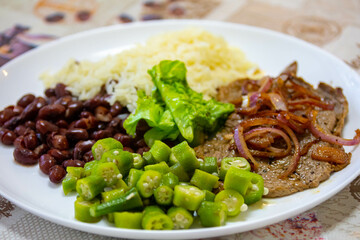 Traditional rustic Brazilian lunch, beans, rice, steak, okra and lettuce. Executive made dish