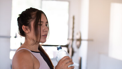 gym lifestyle: woman hydrates herself before starting her next routine. water, bottle, tired,...