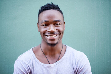 Happy, black man and wall for portrait in outdoor with relaxed facial expression for hearing good...
