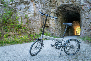 Folding bike on Katy Trail at a tunnel near Rocheport, Missouri, spring scenery. The Katy Trail is 237 mile bike trail converted from an old railroad. - obrazy, fototapety, plakaty