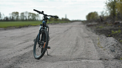 Mountain bike. stands on a field road. spring or autumn. concept of cycling, repair or breakage, sports, outdoor activities. bike on trail, front wheel in focus. healthy lifestyle