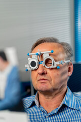close up in an ophthalmology clinic an elderly patient selects a lens checks vision by reading 