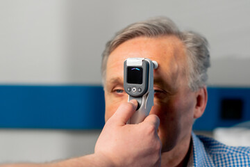 close up in an ophthalmology clinic checking the pressure of the eyeball of an elderly patient
