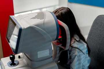 in an ophthalmology clinic little girl diagnoses vision with a red light machine
