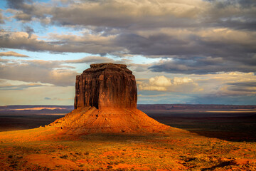 Merrick's Butte in Monument Valley during sunset shows a dramatic view with the setting sun and...