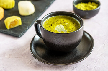 Frothy Matcha Tea in Black Ceramic Cup Close-Up