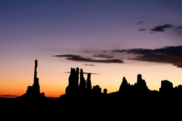 Totem Pole against other spires in Monument Valley during sunrise.