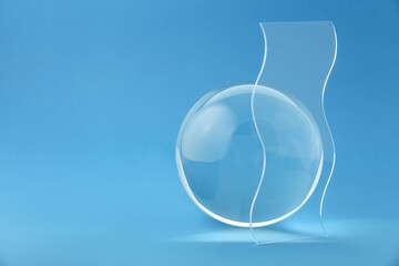 Composition with transparent glass ball on blue background. Space for text