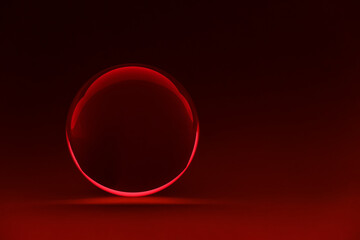 Transparent glass ball on dark red background. Space for text