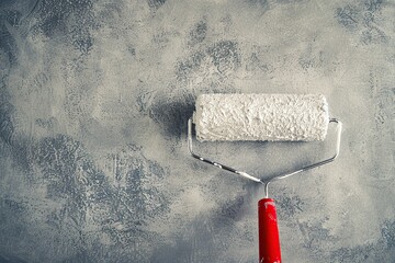 Painting interior wall with paint roller. Painting of walls in a gray color. Close-up house Roller Brush, home improvements, horizontal view with copy space. Paint job for protection and corrosion