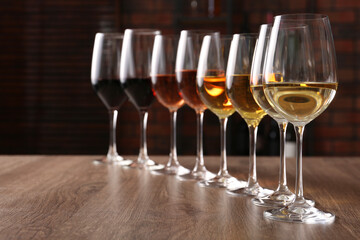 Fototapeta premium Different tasty wines in glasses on wooden table