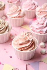 Delicious birthday cupcakes, bunting flags, marshmallows and sprinkles on pink background, closeup