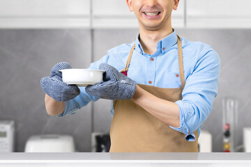 キッチンに立つ笑顔の男性・料理イメージ
