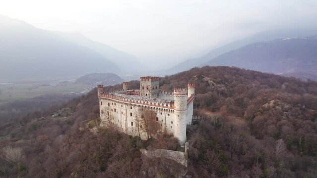 Aerial orbit footage of the castle of Montalto Dora on Craver Mount in winter. Ivrea, Piedmont, Italy