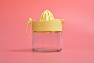 Macro photography of yellow lemon squeezer isolated on pink background