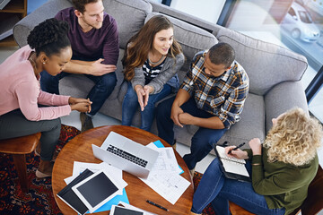 Creative people, meeting and laptop above with team discussion for planning or strategy at office. Top view of employees or group with paperwork or documents for collaboration in startup at workplace