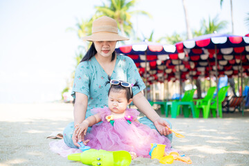 Mother and girl playing in the sand on the beach, Pattaya, Thailand,Mother with children playing with sand on beach