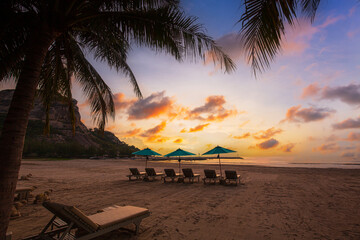 Beaches and sun tables in Thailand,Row of empty sun loungers and orange parasols on the tropical...