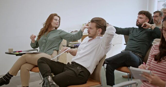 Employees from the company convene in a classroom setting for a collaborative business training, enthusiastically engaging with the material and absorbing valuable knowledge to enhance their skills.