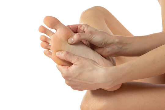 Beauty women's  bare foot with smooth skin in the studio, foot care and self-massage, unrecognizable person