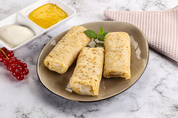 Homemade stuffed pancakes with honey and cream sour