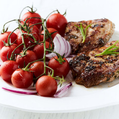 Grilled Chicken Breast with roasted Cherry Tomatoes. Bright wooden background
