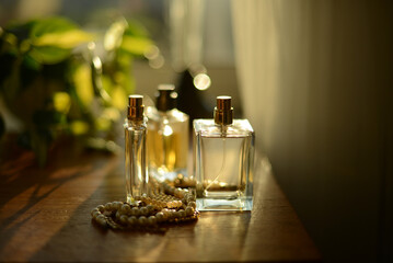 perfume bottles on a dresser by a window, seen in a soft  evening sunlight