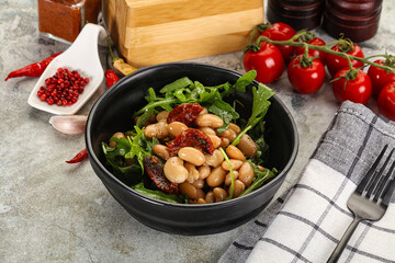 White canned beans with arugula and dry tomatoes