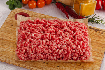 Raw minced beef meat over board