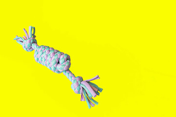 A toy for dogs on a yellow background. Braided form. Pet products