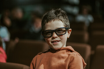 Smiling boy wearing 3D glasses in movie theater