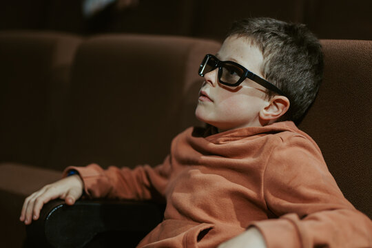 Boy in glasses watching movie during summer