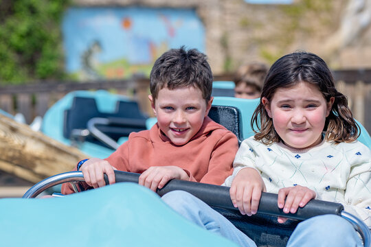 Excited children riding a rollercoaster in summer