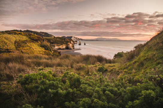 sunset over sea shore rocks and mount Taranaki, New Zealand