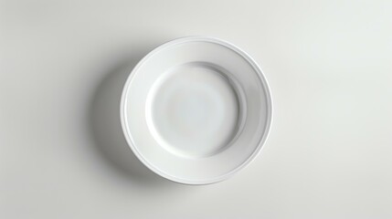 Top view of an empty white plate on a white background. The plate is round and has a wide rim. It is sitting on a white table.