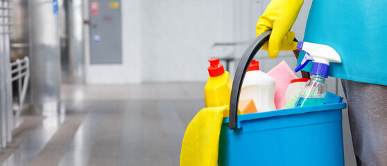 Cleaning woman with cleaning products in a bucket.