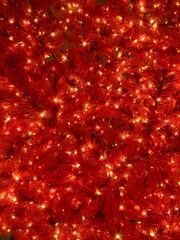 Red branches of a Christmas pine tree as a garland background, glowing lights in focus. new year...