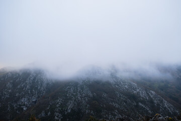Landscape of a mountain and fog rolling down the slope