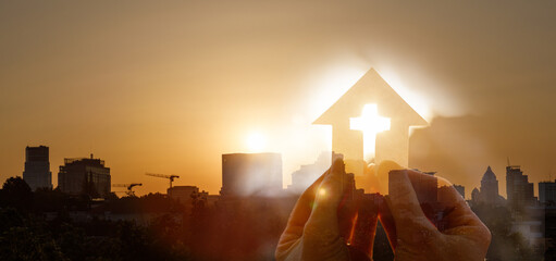 Double exposure of cut out paper church and city sunset.