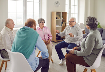 Group of elderly people talking on therapy session at nursing home. Senior men and women sitting in circle and having conversation and discussing some problems together. Psychotherapy concept. - 796954780