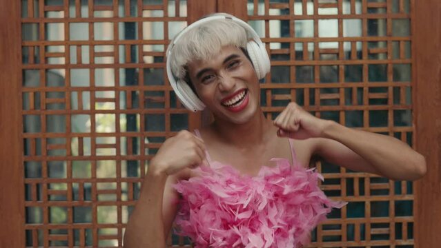 Handsome Happy Energetic Transvestite Freely Dances on the Street. Enthusiastic Queer Man Is Enjoying the Music Outdoors. LGBT People and Technology Concept