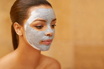 Woman, cosmetics and mud mask at spa, facial treatment and detox or cleaning dermatology. Female...