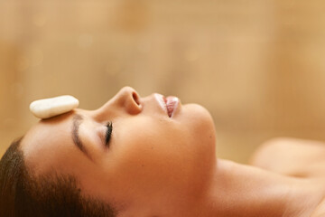 Woman, sleeping and spa with rock for facial treatment, zen or stress relief at luxury resort....