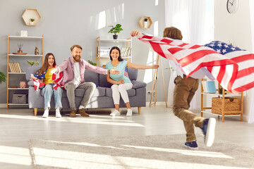 Happy funny children having fun and running with flags of united states in living room at home celebrating Independence Day with parents. Family patriotism and US patriotic holiday concept. - 796964394