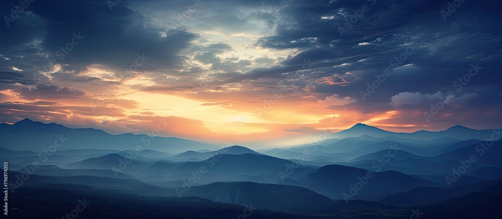 Poster Mountains silhouetted against a setting sun