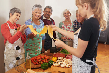 Cooking, pasta class and woman with people in kitchen learning recipe for cuisine, culinary and chef skills. Retirement, teacher and and men and women with ingredients, dough and food for dinner